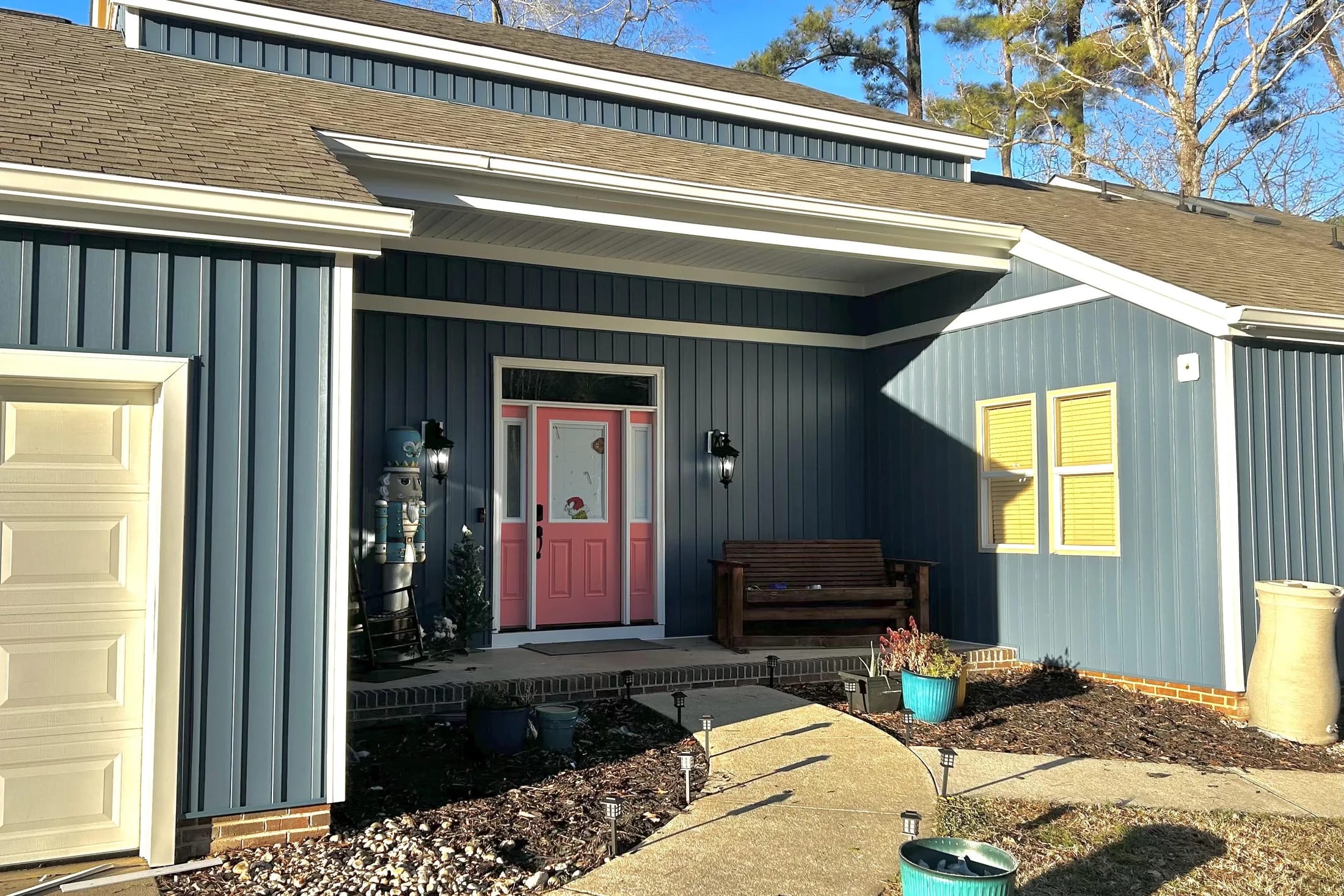 Dark vertical board and batten siding with warm shingle gables.