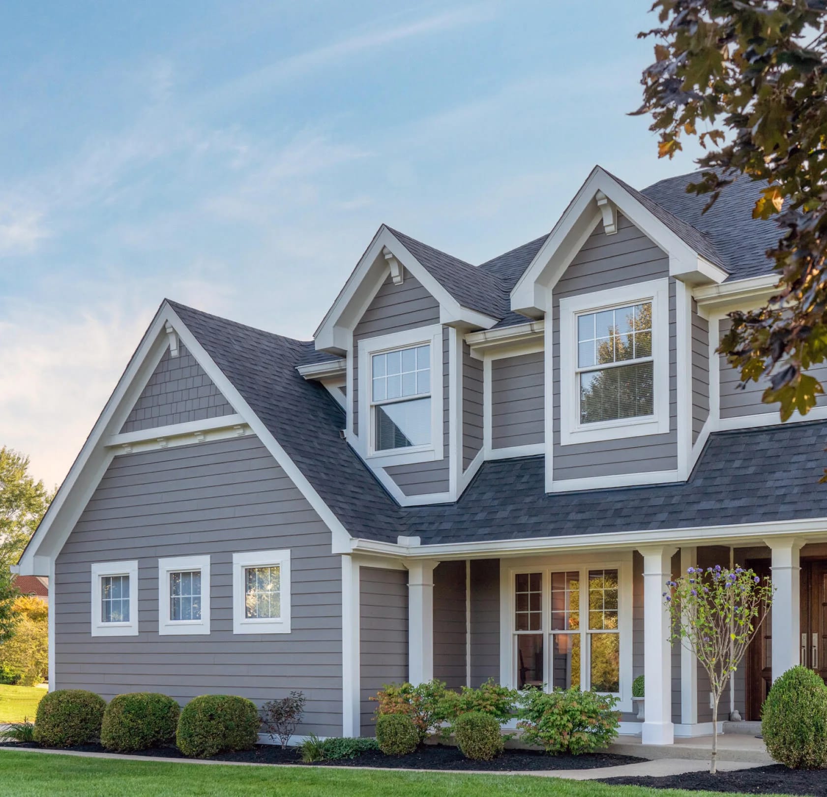 Finished home with vertical James Hardie siding and warm shingle accents.