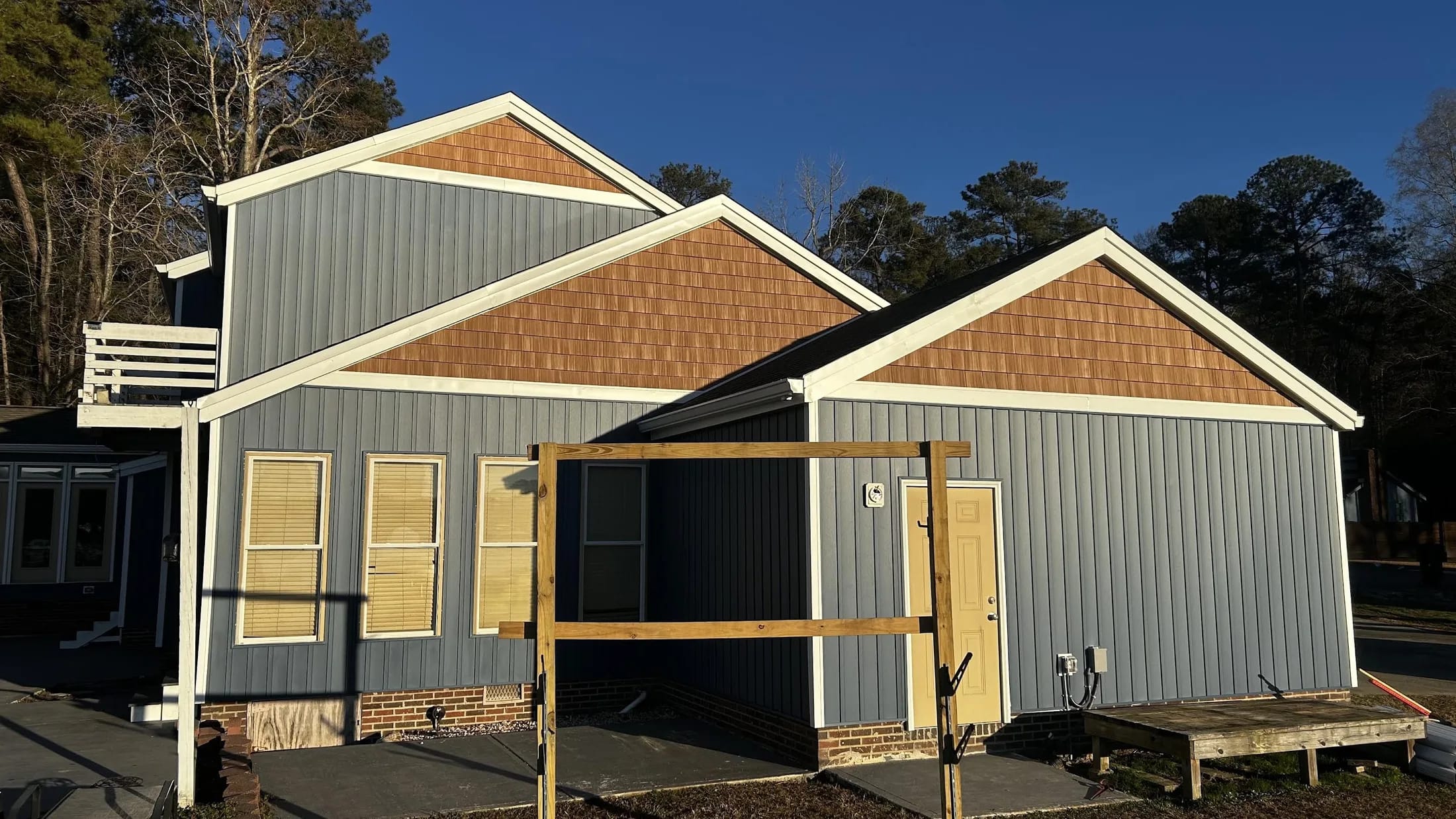 Finished house with warm shingle siding across the gables.